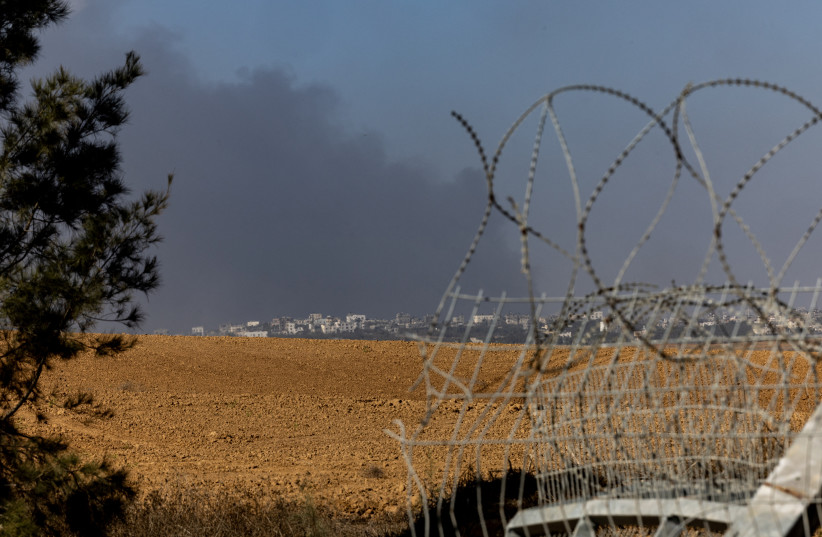  Smoke rises from Gaza as seen from the broken fence where Hamas terrorists entered Israel during the October 7th attack, in Kfar Aza, Israel November 8, 2023 (credit: REUTERS/EVELYN HOCKSTEIN)