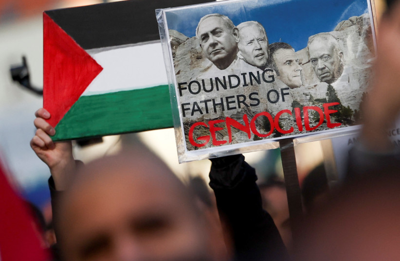 A demonstrator holds a placard depicting Israeli Prime Minister Benjamin Netanyahu, U.S. President Joe Biden, French President Emmanuel Macron and Israeli Defense Minister Yoav Gallant during a protest in support of Palestinians in Gaza, as the conflict between Israel and Palestinian terroris group  (credit: YVES HERMAN/REUTERS)