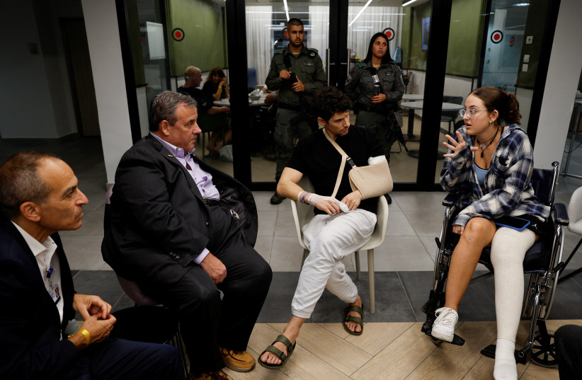  Former New Jersey Governor Chris Christie talks with Yadin, a soldier, and Sheerel Gabay, survivor of the Nova Festival, that were injured in the October 7 deadly attack by gunmen from terror group Hamas on southern Israel, at Sourasky Medical Center (Ichilov) in Tel Aviv, Israel  (credit: REUTERS/AMIR COHEN)