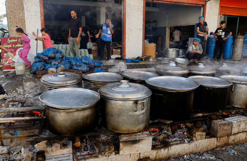  Palestinians cook on firewood, amid fuel and cooking gas shortages, as the conflict between Israel and Hamas continues, in Khan Younis in the southern Gaza Strip, November 5, 2023.  (credit: REUTERS/IBRAHEEM ABU MUSTAFA)
