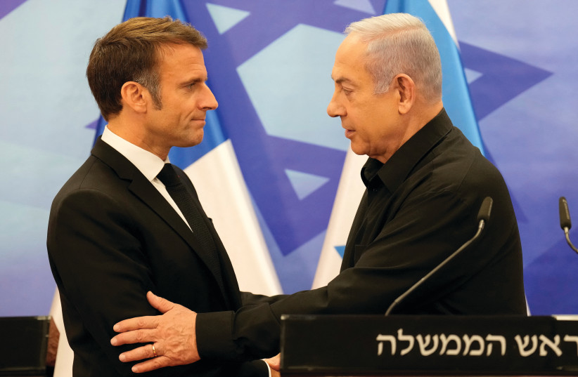  Prime Minister Benjamin Netanyahu and French President Emmanuel Macron embrace at a joint news conference in Jerusalem last month. Macron called for the anti-ISIS coalition to regroup against Hamas. (credit: CHRISTOPHE ENA/REUTERS)