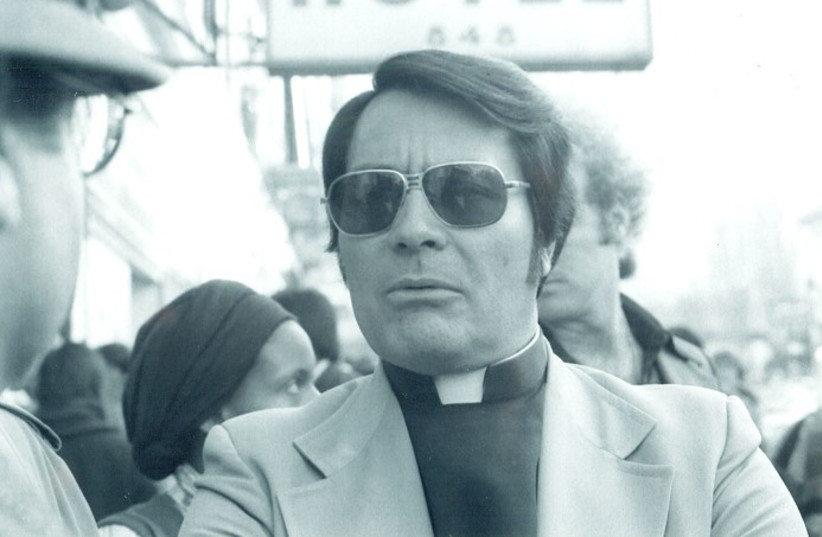  REVEREND JIM JONES at an anti-eviction protest in San Francisco, 1977. Bodyguard and adopted Jones son Tim Tupper behind Jones is talking to Cheryl Wilhite, a Peoples Temple security guard.  (credit: Wikimedia Commons)