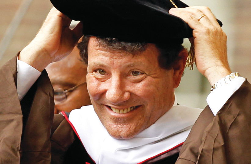  NICHOLAS KRISTOF adjusts his mortar board after receiving an honorary Doctor of Letters from Brown University. (credit: Adam Hunge/Reuters)