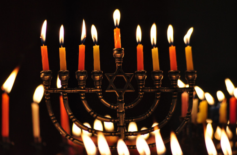  A Hanukkah menorah with lit candles. (credit: FLICKR)