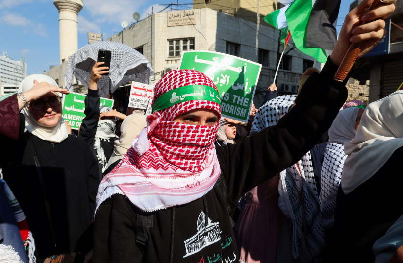  Demonstrators carry banners and flags during a protest in support of Palestinians in Gaza, amid the ongoing conflict between Israel and the Palestinian Islamist group Hamas, in Amman, Jordan November 17, 2023.  (credit: REUTERS/JEHAD SHELBAK)
