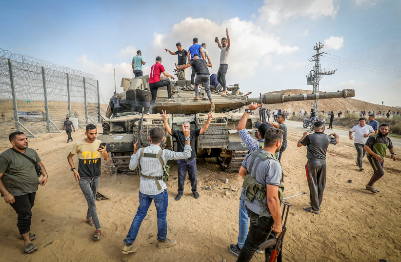 Palestinos toman el control de un tanque israelí tras cruzar la valla fronteriza con Israel desde Khan Yunis, en el sur de la Franja de Gaza, el 7 de octubre de 2023.  (crédito: ABED RAHIM KHATIB/FLASH90)