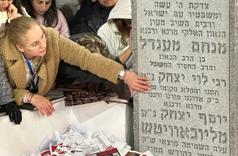  A family member of a hostage touches the grave of the late Rabbi Menachem Mendel Schneerson. (credit: Chaim Tuito)