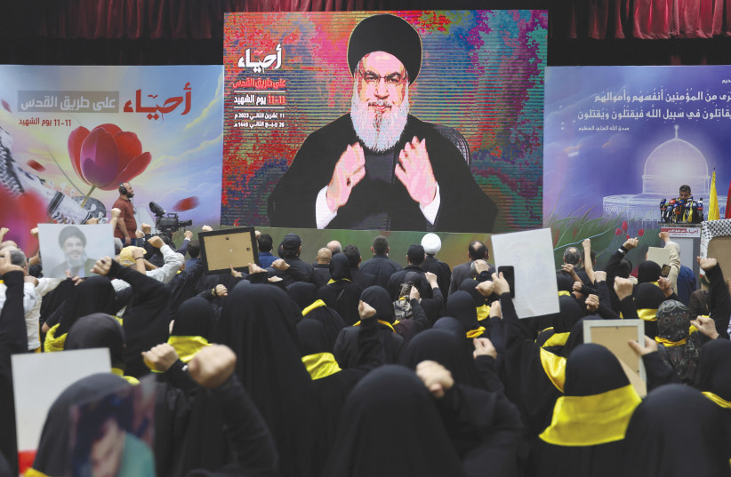  HEZBOLLAH LEADER Sheikh Hassan Nasrallah adresses supporters on screen at a rally marking the annual Hezbollah Martyrs' Day, in Beirut's southern suburbs, earlier this month (credit: AZIZ TAHER/REUTERS)