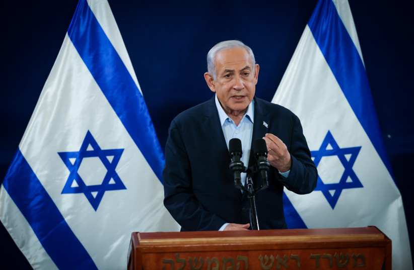 El primer ministro Benjamin Netanyahu habla con los medios el 22 de noviembre de 2023 (crédito: Chaim Goldberg/Flash90)