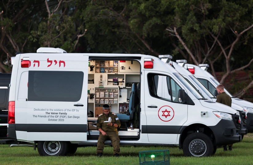  An ambulance awaiting the arrival of a vehicle carrying hostages released as part of a deal between Israel and Hamas at Schneider Children's Medical Center in Petah Tikva, Israel, November 24, 2023 (credit: REUTERS/Ronen Zvulun)