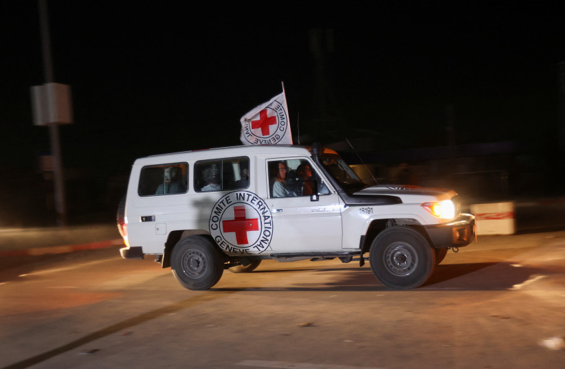  A red cross vehicle, which is part of a convoy arrives at the Rafah border crossing, amid a hostages-prisoners swap deal between Hamas and Israel, in the southern Gaza Strip November 24, 2023 (credit: REUTERS/IBRAHEEM ABU MUSTAFA)