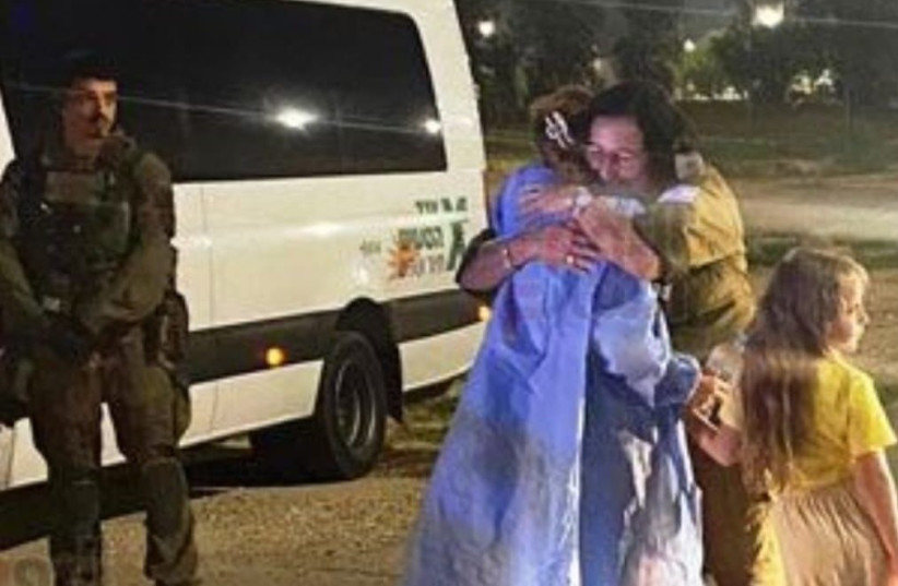 Uma refém israelense e sua filha são vistas abraçando um oficial das FDI durante sua libertação do cativeiro do Hamas em 24 de novembro de 2023 (crédito: VIA MAARIV ONLINE)