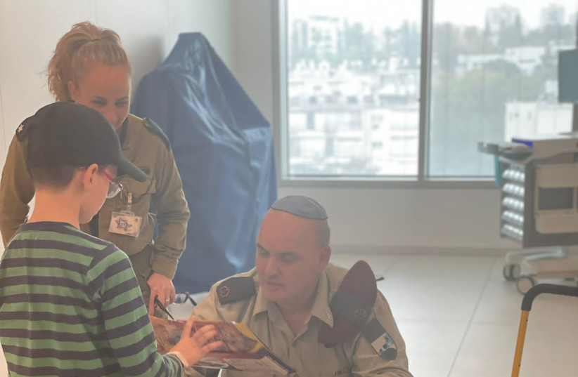  Ohad Munder receives some late gifts, having spent his 9th birthday as a hostage. (credit: IDF SPOKESMAN’S UNIT)