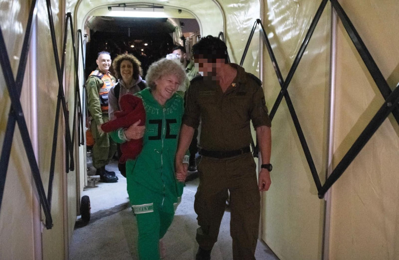  Adina Moshe smiling as she walks hand in hand with a soldier back in Israel. (credit: IDF SPOKESPERSON'S UNIT)