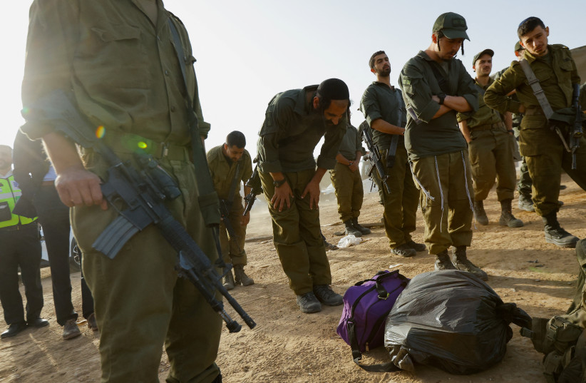  Israeli soldiers pray near the Israel-Gaza border on its Israeli side during a temporary truce between Hamas and Israel, in southern Israel, November 26, 2023 (credit: REUTERS/ALEXANDER ERMOCHENKO)