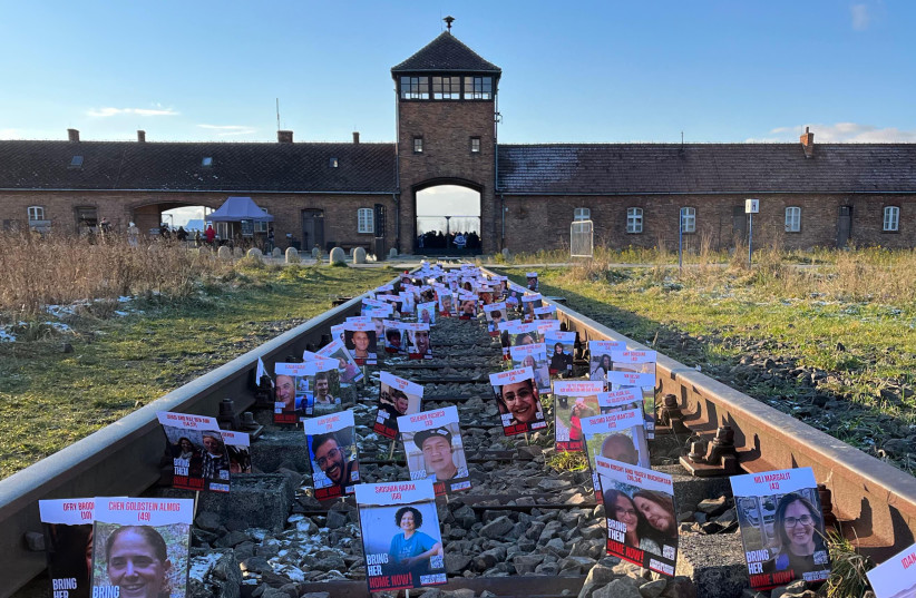  British students on a trip to Poland placed pictures of the nearly 200 Israeli hostages still in Hamas captivity on the train tracks leading up to the Auschwitz-Berkenau death camp, on November 26, 2023. (credit: JROOTS)