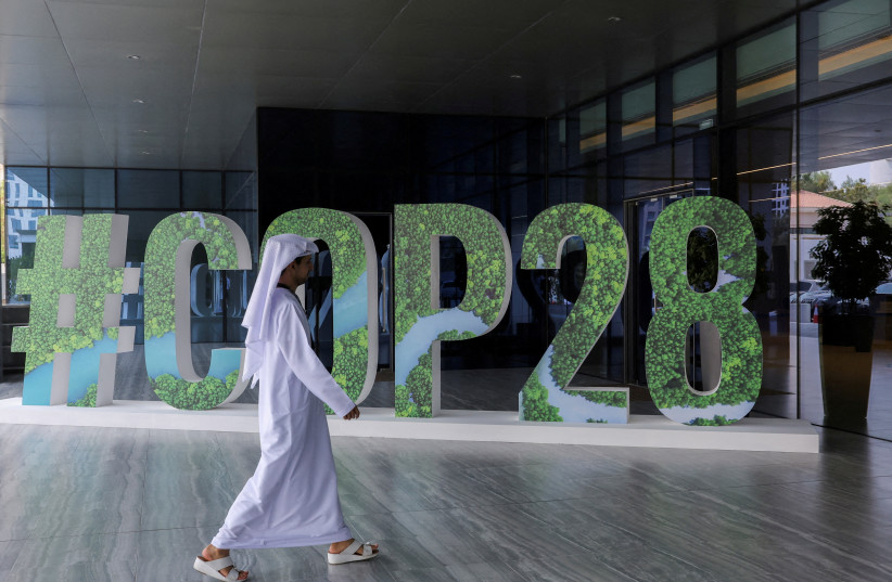  A person walks past a ''#COP28'' sign in Abu Dhabi, United Arab Emirates, October 1, 2023 (credit: REUTERS/AMR ALFIKY)