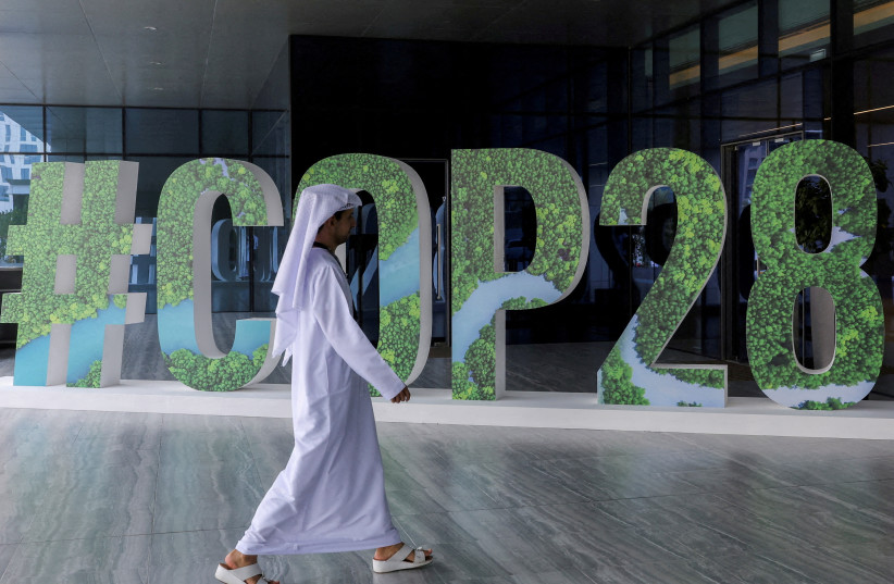  A person walks past a ''#COP28'' sign during The Changemaker Majlis, a one-day CEO-level thought leadership workshop focused on climate action, in Abu Dhabi (credit: REUTERS)