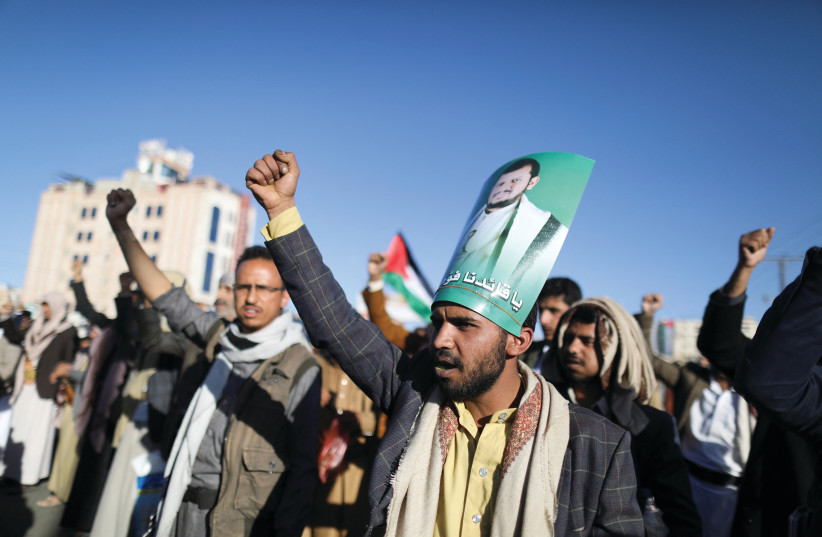  A MAN wears a placard strapped to his head depicting Houthi leader Abdul-Malik al-Houthi, at a pro-Palestinian rally in Sanaa, Yemen, last Friday. (credit: KHALED ABDULLAH/REUTERS)