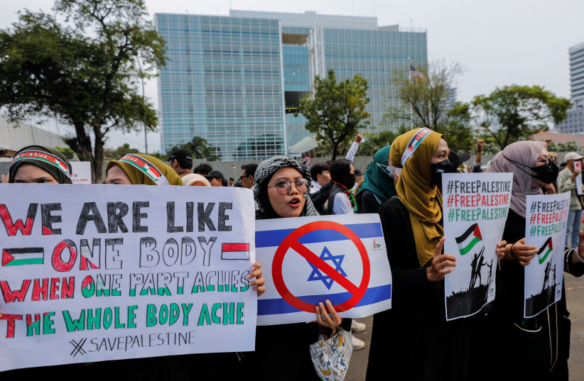  Pro-Palestinian supporters carrying placards take part in a rally, amid the ongoing conflict between Israel and the Palestinian Islamist group Hamas, outside the U.S. embassy in Jakarta, Indonesia, October 20, 2023. (credit: REUTERS/WILLY KURNIAWAN)