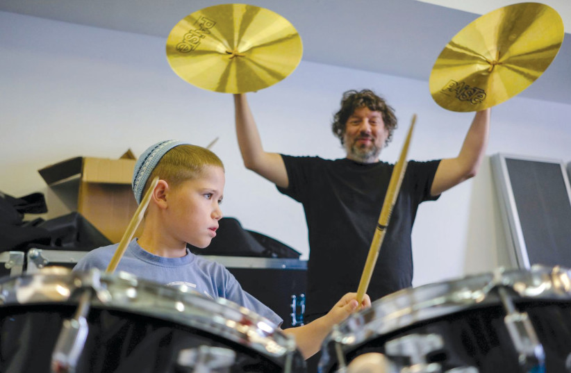  JERUSALEM STREET Orchestra percussionist Cnaan Canetti keeps time with a young drummer. (credit: YAEL ILAN)