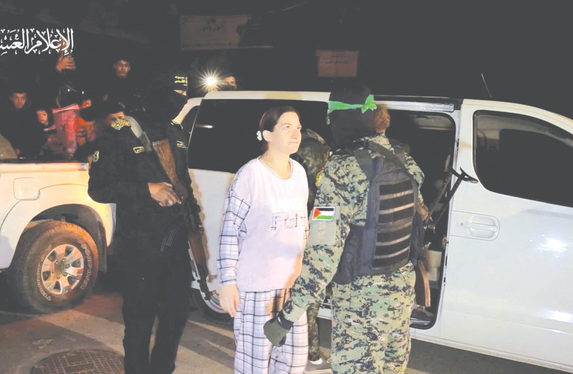  HOSTAGE RIMON KIRSHT, wearing pink pajamas, boldly stares with unwavering disdain into the eyes of a masked and heavily armed Hamas terrorist upon her release this week. (credit: REUTERS)