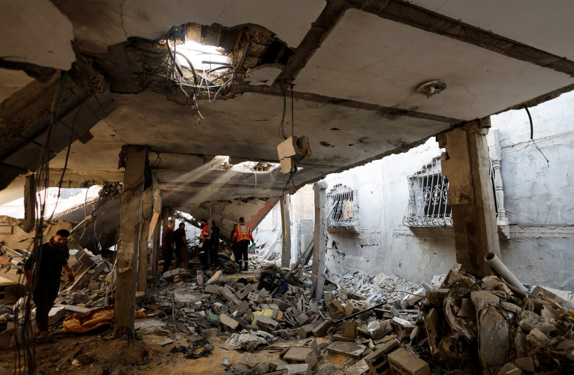 Palestinians inspect the damage following an Israeli strike on a house after a temporary ceasefire between Hamas and Israel ended, in Khan Yunis in the southern Gaza Strip, December 1, 2023 (credit: MOHAMMED SALEM/REUTERS)
