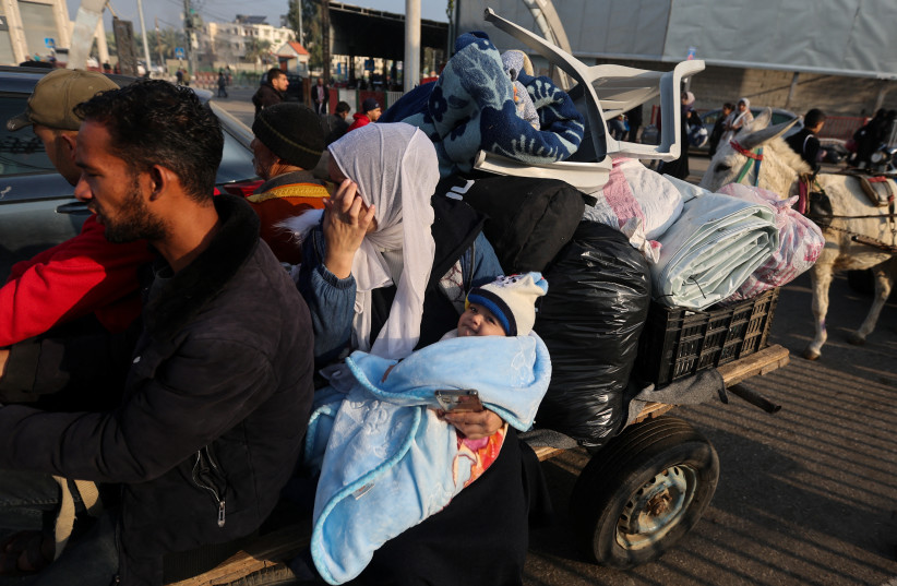  A woman holding a child sits on a trailer, as Palestinians flee their houses due to Israeli strikes, after a temporary ceasefire between Hamas and Israel ended, in the eastern part of Khan Yunis in the southern Gaza Strip, December 1, 2023 (credit: IBRAHEEM ABU MUSTAFA/REUTERS)