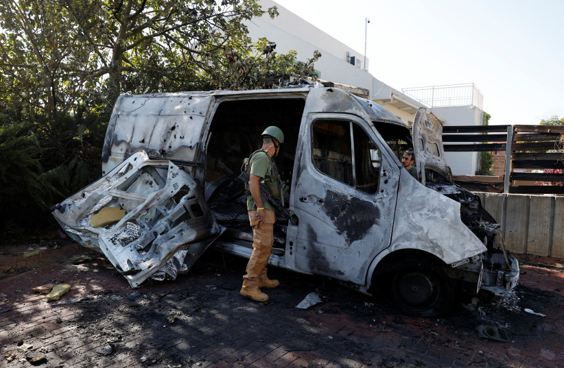  Security personnel check a car hit by a rocket fired today from the Gaza Strip, after a temporary truce expired between Israel and the Palestinian terrorist group Hamas, in a kibbutz near the border with Gaza, in southern Israel, December 1, 2023. (credit: AMIR COHEN/REUTERS)