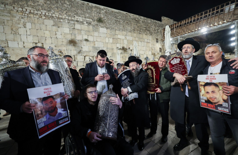 Haredi Jews dance with two new Torah scrolls dedicated to the return of the hostages and in memory of the civilians and soldiers killed in the Oct. 7 massacre, and ongoing war, at the Western Wall in Jerusalem's Old City, November 21, 2023. (credit: YONATAN SINDEL/FLASH90)