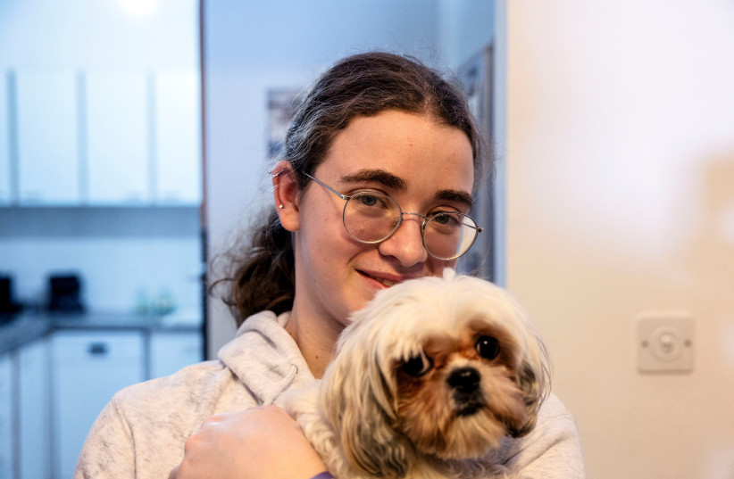 Mia Leimberg, 17, released from captivity after being taken hostage by Hamas in the Gaza Strip with her mother Gabriela and her dog Bella, holds the dog in her arms at their home in Jerusalem, December 5, 2023. Mia's uncle and aunt's partner remain in captivity. (credit: REUTERS/Ronen Zvulun)