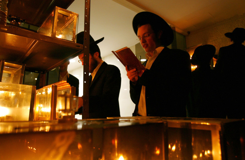 Students from the Mir Yeshiva, a Jewish learning seminary, recite prayers while lighting candles for the Jewish holiday of Hanukkah in the Mea Shearim neighbourhood of Jerusalem (credit: REUTERS/RONEN ZVULUN (JERUSALEM))