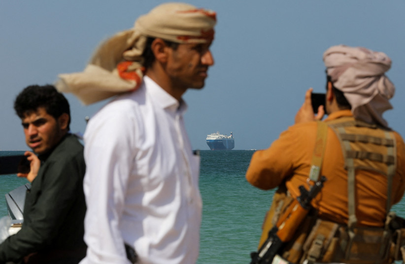  People stand on the beach as the ‘Galaxy Leader’ commercial ship, seized by Yemen’s Houthis last month, is anchored off the coast of al-Salif, Yemen, last week. (credit: KHALED ABDULLAH/REUTERS)