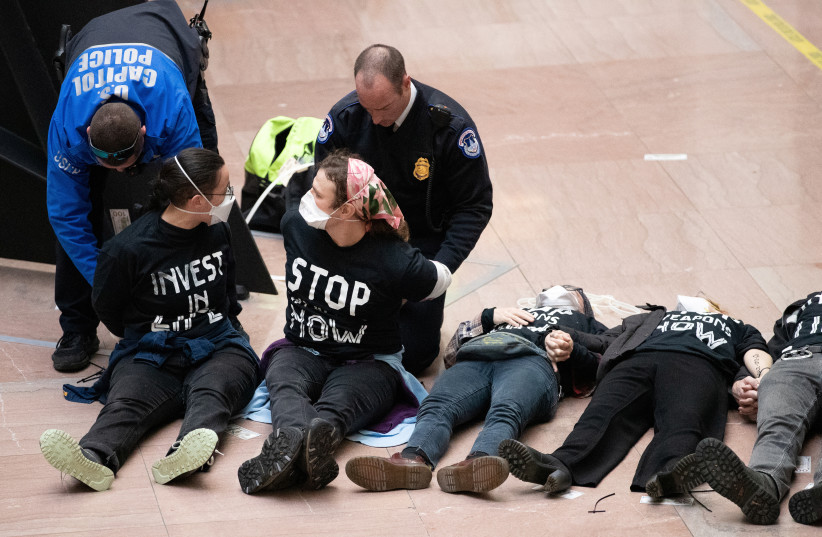 Activists engage in civil disobedience in Hart Senate Office Building, part of the U.S. Capitol complex, to call for a permanent ceasefire in Gaza and redirection of military aid for Israel, in Washington, U.S. December 11, 2023.  (credit: ALLISON BAILEY/REUTERS)