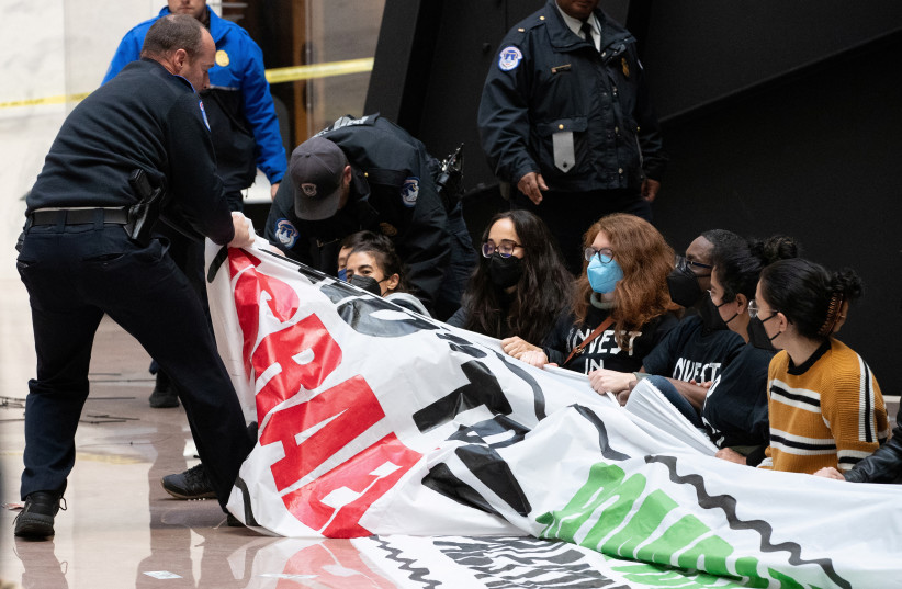 Activists engage in civil disobedience in Hart Senate Office Building, part of the U.S. Capitol complex, to call for a permanent ceasefire in Gaza and redirection of military aid for Israel, in Washington, U.S. December 11, 2023. (credit: ALLISON BAILEY/REUTERS)