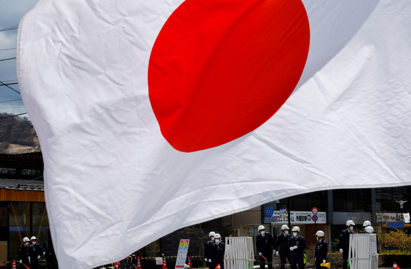  Policemen standing guard are seen behind a Japanese national flag held by a protester during a rally welcoming G7 Foreign Ministers' meeting in Karuizawa, Japan, April 16, 2023 (credit: REUTERS/KIM KYUNG-HOON)