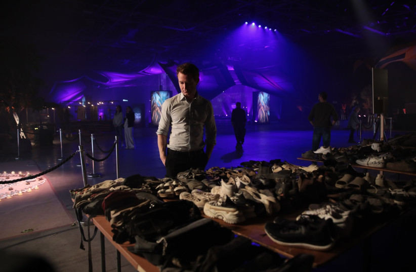 - Douglas Murray looks at a table with shoes, purses, and other belongings left behind by festivalgoers who were murdered by Hamas at the Nova Music Festival, at an exhibit at the Tel Aviv Expo center, Dec. 7, 2023.  (credit: MOSHE MIZRAHI)