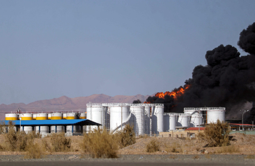 Smoke rises at an oil refinery in Birjand, Iran, December 10, 2023.  (credit: Mohsen Noferesti/IRNA/WANA Handout via REUTERS)