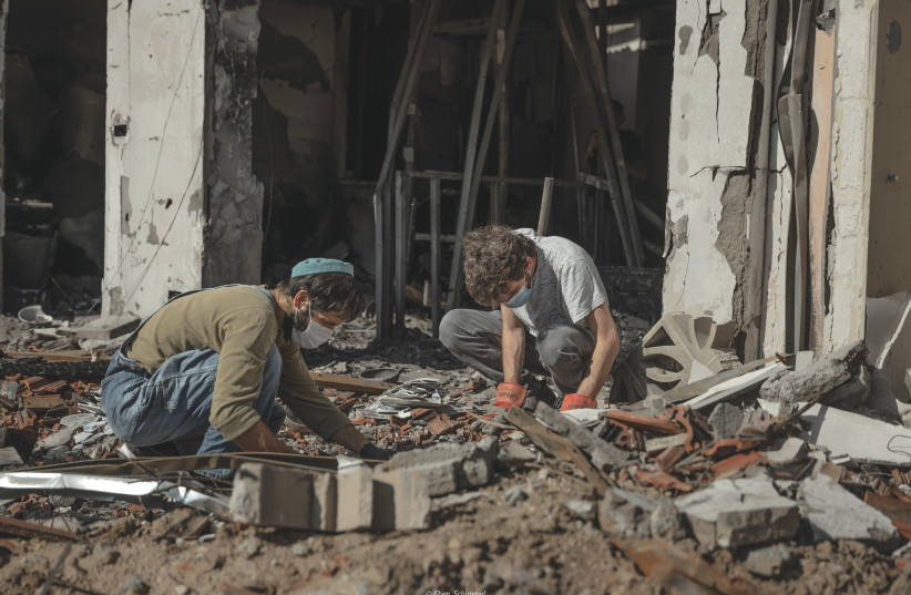  Members of a family, in which the father was murdered by Hamas terrorists on October 7, search in the rubble of his home in Kibbutz Be'eri for memories. The Middle East will no longer be the same, the writer asserts. (credit: CHEN SCHIMMEL/FLASH90)