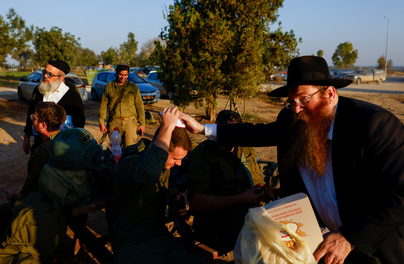  A rabbi brings sweets as Israeli soldiers rest near the Gaza Strip border in southern Israel, December 19, 2023 (credit: REUTERS/CLODAGH KILCOYNE)