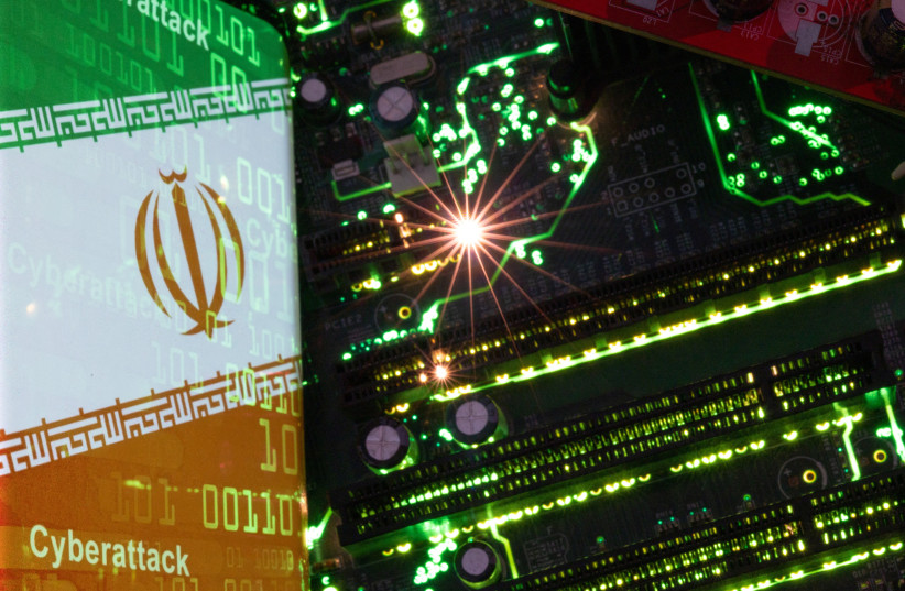  A smartphone with a displayed Iranian flag with the word ''Cyberattack'' and binary codes over it is placed on a computer motherboard in this illustration taken February 23, 2023.  (credit: REUTERS/DADO RUVIC/ILLUSTRATION)