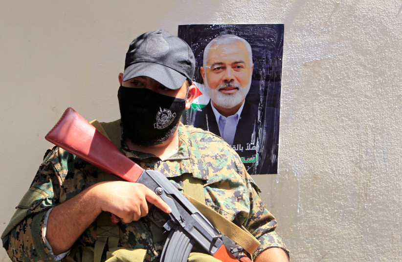  A Hamas terrorist stands in front of a picture of the group's top leader Ismail Haniyeh during his visit at Ain el Hilweh Palestinian refugee camp in Sidon, Lebanon September 6, 2020 (credit: REUTERS/AZIZ TAHER)