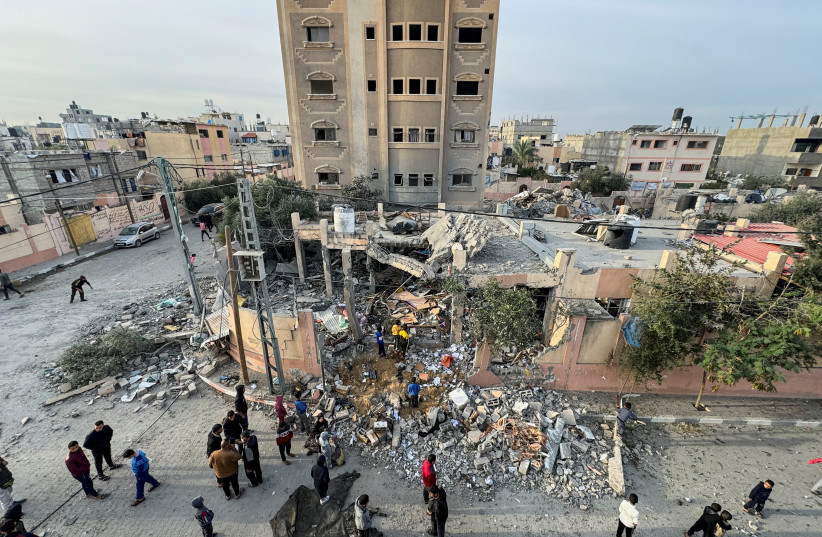  Palestinians gather at the site of an Israeli strike on a house, amid the ongoing conflict between Israel and Hamas n the southern Gaza Strip, December 20, 2023.  (credit: REUTERS/BASSAM MASOUD)
