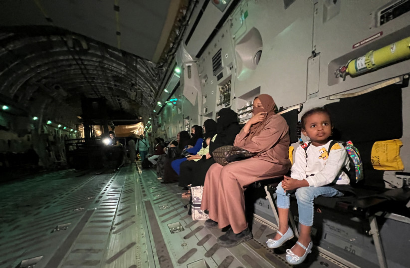  A family sits inside a military aircraft at Port Sudan International Airport waiting to get evacuated to Qatar, in Sudan May 4, 2023. (credit: REUTERS/IMAD CREIDI)