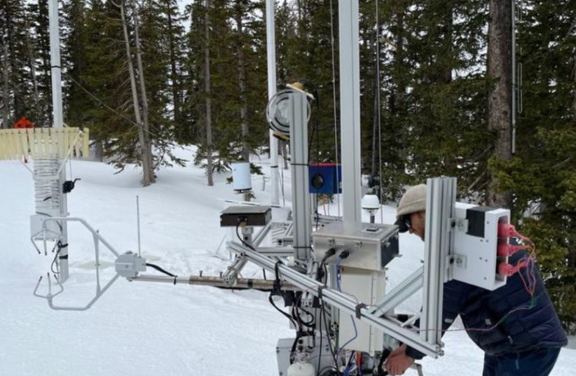  Graduate student Ryan Szczerbinski examines instrumentation called a differential emissivity imaging disdrometer developed by University of Utah. The equipment measures the hydrometeor mass, size, and density of snowflakes. (credit:  Tim Garrett/University of Utah)