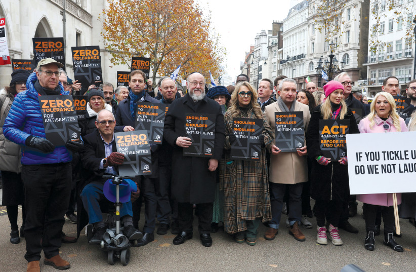  Britain’s Chief Rabbi Ephraim Mirvis, actor Eddie Marsan, and TV personality Vanessa Feltz hold posters at a march against the rise of antisemitism in the UK in London on November 26. (credit: Susannah Ireland/Reuters)