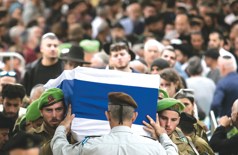  FAMILY AND friends walk behind the coffin of Sgt. Lavi Ghasi, 19, at his funeral yesterday in Modi’in.  (credit: Amir Levy/Getty Images)