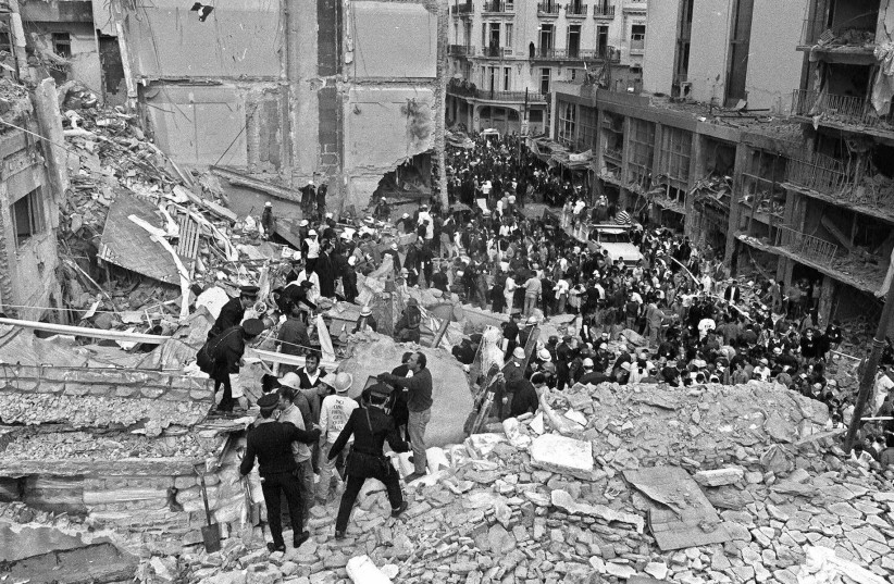  Firefighters and police officers search for victims of the AMIA center bombing in Buenos Aires, July 18, 1994.  (credit: Ali Bufari/AFP/Getty Images)