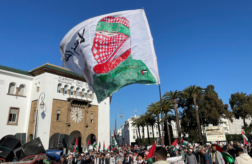  Protesters display a flag with an image of a Palestinian militant, at a demonstration calling for an end to Morocco's ties with Israel, amid the ongoing conflict between Israel and Hamas, in Rabat, Morocco December 24, 2023.  (credit: REUTERS/Ahmed El Jechtimi)