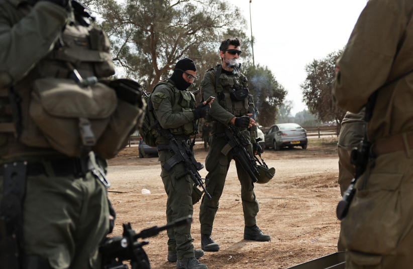  An Israeli soldier looks at his phone, December 25, 2023 (credit: REUTERS/VIOLETA SANTOS MOURA)